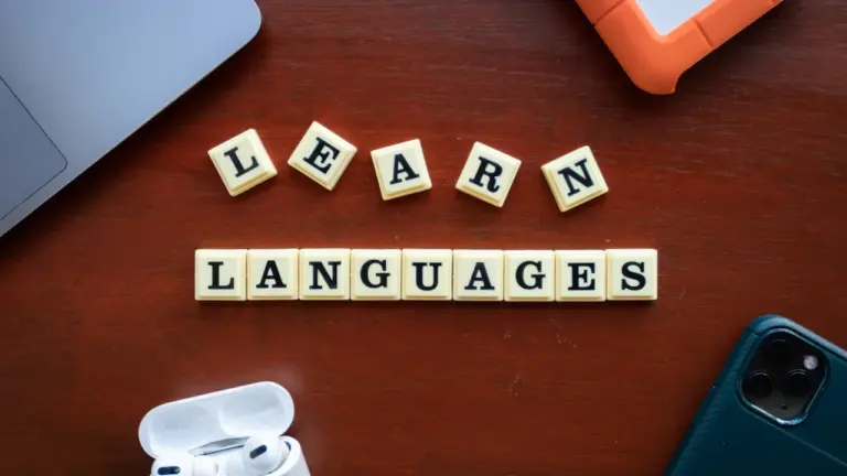 Des lettres de Scrabble forment le mot apprendre les langues sur un bureau.