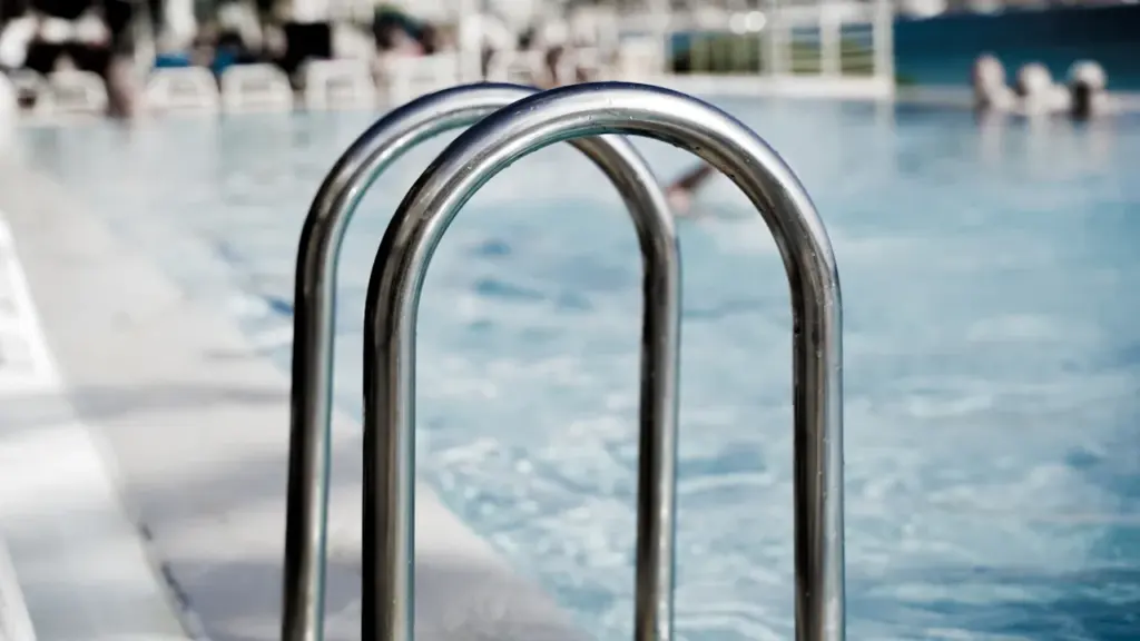 Gros plan sur l'échelle métallique d'une piscine publique classique.