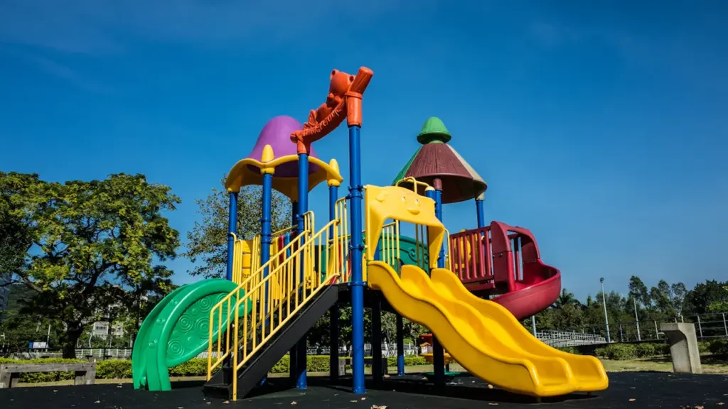 Structure de jeux colorée pour enfants dans un parc public ensoleillé à Lille.