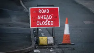 Panneau de signalisation route barrée avec cône de chantier sur une voie publique.