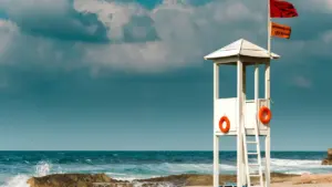 Poste de secours blanc sur une plage sous un ciel menaçant à Toulon.