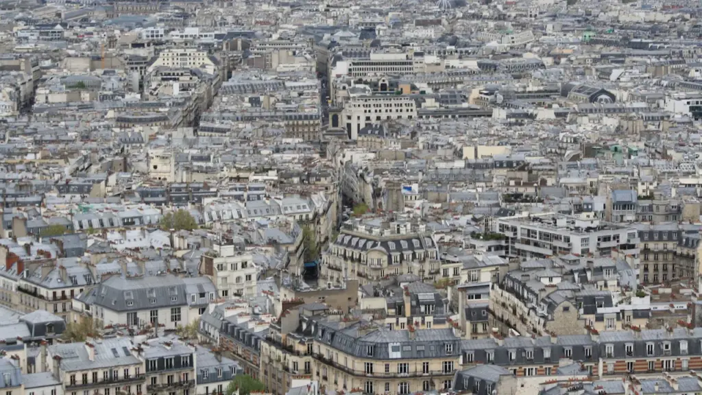 Vue aérienne étendue des toits et immeubles caractéristiques d'une ville française dense.