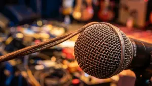 Gros plan sur un microphone de studio avec une corde de guitare enroulée dessus.