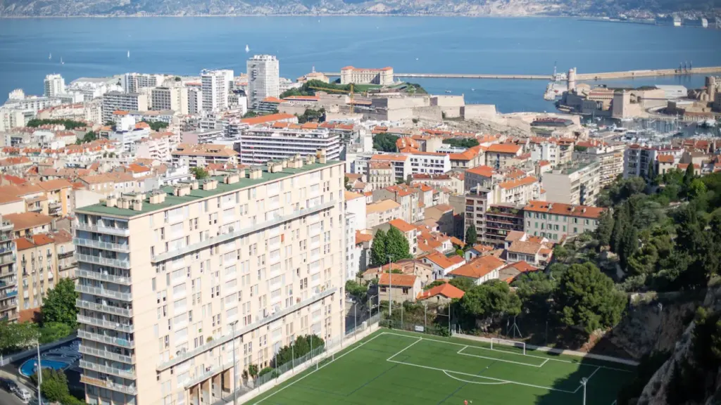 Vue panoramique en plongée sur la ville de Marseille et son stade de quartier.