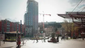 Une place urbaine animée à Saint-Étienne avec des piétons et des bâtiments modernes.