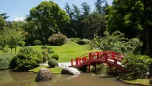 Le pont rouge du jardin japonais de Compans-Caffarelli sous un ciel menaçant à Toulouse.