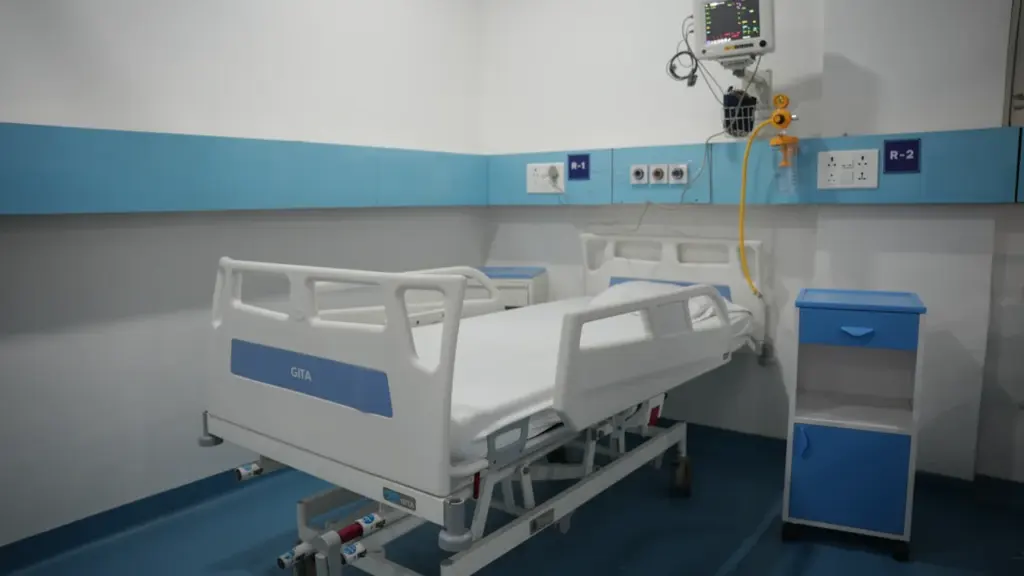 Chambre d'hôpital moderne équipée d'un lit médicalisé réglable et d'un écran de contrôle.