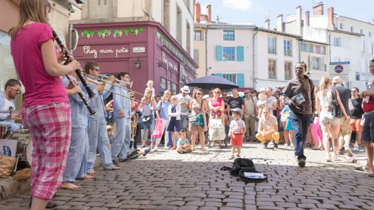 Une fanfare de rue anime le centre-ville historique lors d'un festival estival en France.