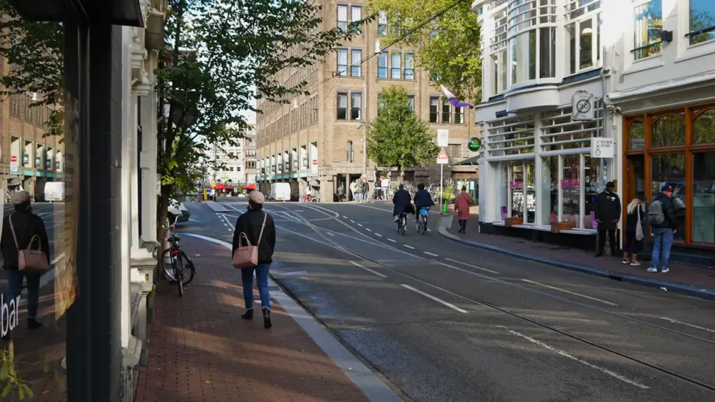Une rue animée avec des passants profitant d'une journée ensoleillée en ville.