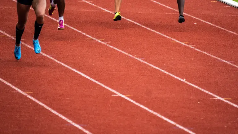 Athlètes courant sur une piste d'athlétisme lors d'une compétition en France.