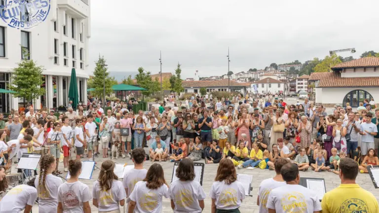 Un groupe de jeunes musiciens jouant des cuivres devant une foule attentive en extérieur.