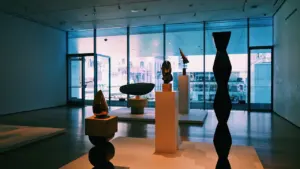 Une galerie d'art contemporain lumineuse avec des sculptures sur des socles en bois.