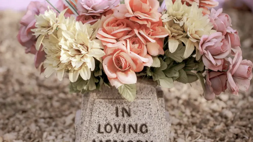 Fleurs déposées sur une stèle commémorative pour un devoir de mémoire solennel.