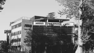 Façade de l'Université Claude Bernard Lyon 1 avec des arbres au premier plan.